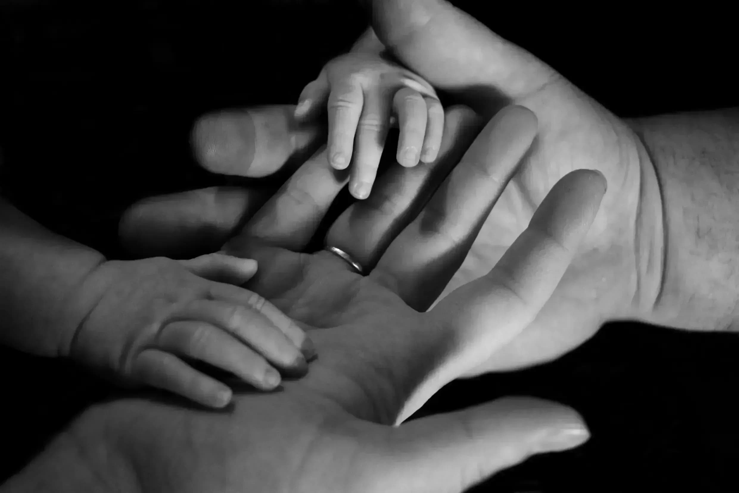 Grayscale Photo of Family Holding Hands